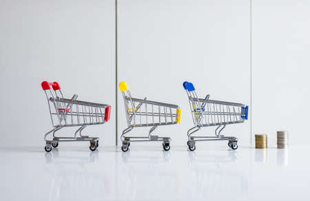 Mini shopping cart with step of coins stacks,Finance and money shopping conceptの写真素材