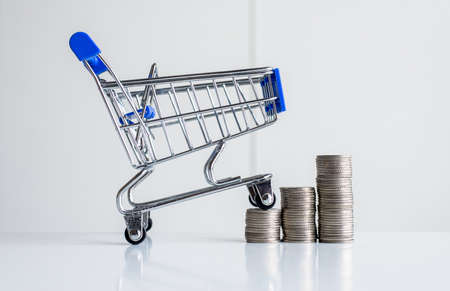 Mini shopping cart with step of coins stacks,Finance and money shopping conceptの写真素材