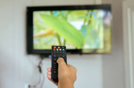 Hand using with TV remote control at home,Close upの写真素材