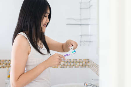 Young asian woman brush the teeth in bathroom after wake up in morningの写真素材