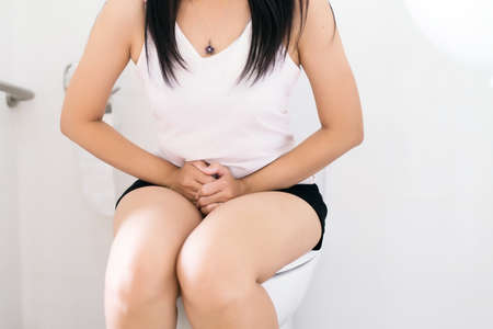 Woman using toilet after wake up in morning,Pants is hanging on her legsの写真素材