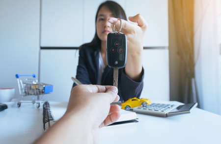 Giving car key on hand for vehicle sales agreement,Car finance and loan conceptの写真素材