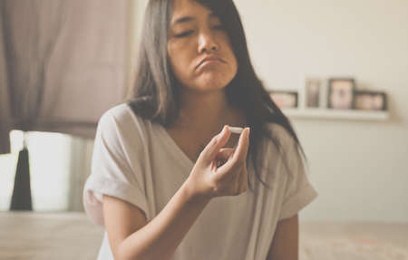Female hand holding a medicine,Woman hands with pills on spilling pills but do not take a medicine ,emotional face expression,Selective focusの写真素材