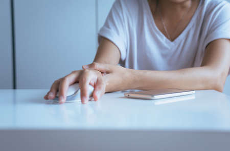 Young asian woman having a wrist or hand pain,Female feeling exhausted and painful,Because clicking the mouse.の写真素材