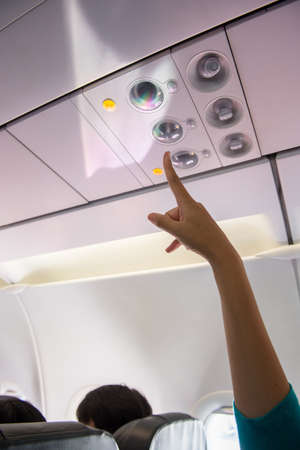 Hand using air conditioner and light symbol on aircraft