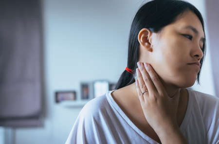 Woman have a sore throat,Female touching neck with hand,Healthcare Concepts