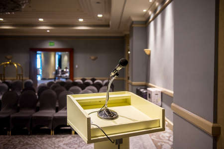 Microphone on blurred in seminar room or conference hall background
