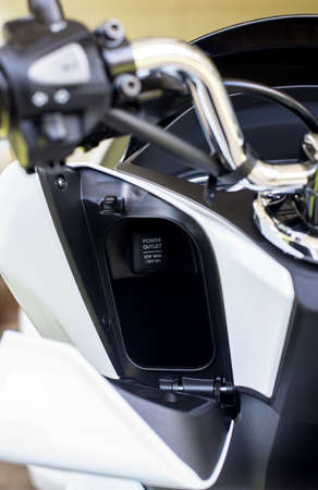 Power outlet for charger mobilephone on a modern motorcycle,Close up and selective focus