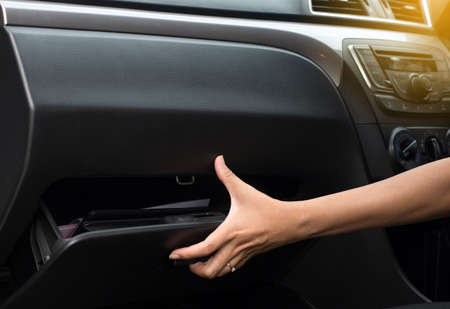 Hand open glove compartment box inside modern car