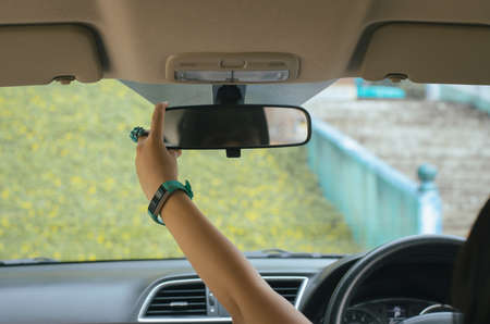 Hand using rear view mirror in the car,Transportation and vehicle safety concept,