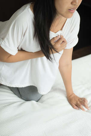 Asian woamn having or symptomatic reflux acids,Gastroesophageal reflux disease,Because the esophageal sphincter that separates the esophagus and stomach dysfunctionの写真素材