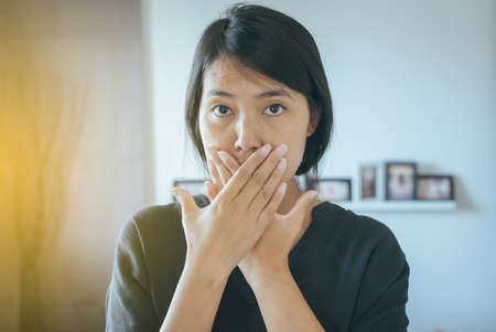 Asian woman covering her mouth and smell her breath with hands,Bad smellの写真素材