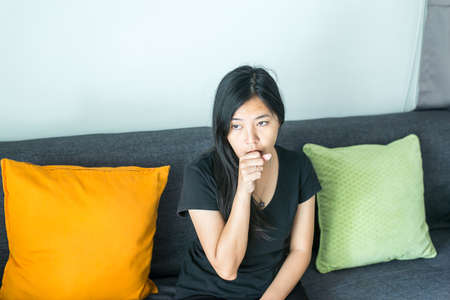 Womanhave a fever and coughing in living room,Concept of health