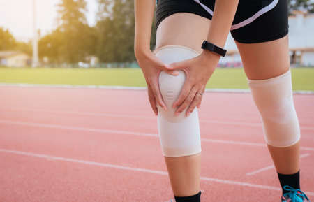 Woman suffering from pain in leg with knee running jogging and workout outdoorの写真素材