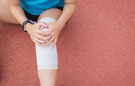 Woman runner suffering from pain in legs be injured,Hands touching her kneeafter jogging and workout...
