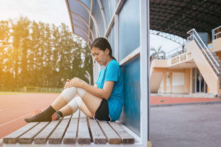 Woman suffering from pain in leg injury after sport exercise running jogging and workout outdoorの写真素材