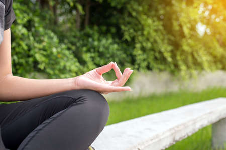 Woman sitting  practicing doing yoga exercise,workout after waking up at public park,Healthy and  lifestyle concept,Selective focusの写真素材