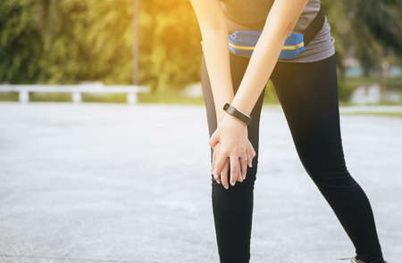 Woman suffering from pain in leg injury after sport exercise running jogging and workout outdoo,Hand...
