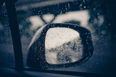Blurred traffic on rainy day in the city,Car window with rain drops on glass or the windshield