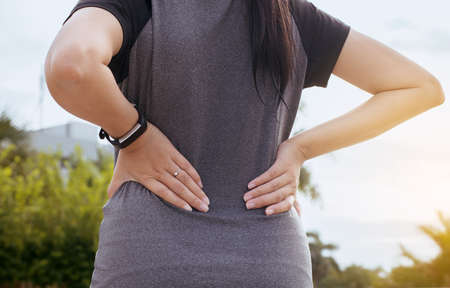 Woman suffering from pain have a backache after sport exercise running jogging and workout outdoor