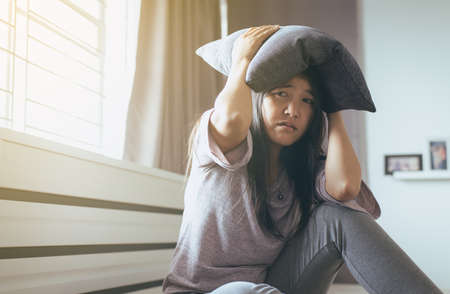 Depressed woman patient with pillow on head,Meantal health care conceptの写真素材