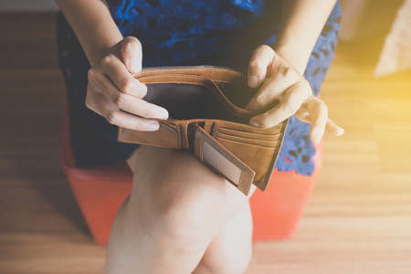 Broke woman hands holding Empty wallet,Concept having cost control expenses,No moneyの写真素材