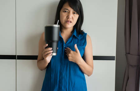 Asian woamn having or symptomatic reflux acids,Gastroesophageal reflux disease,Because the esophageal sphincter that separates the esophagus and stomach dysfunctionの写真素材