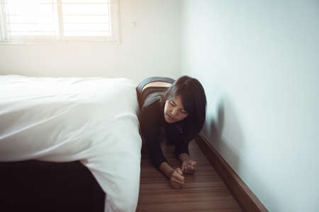 Woman bent and searching something under bed lost thingの写真素材