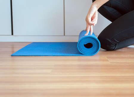 Woman hand rolling or folding blue yoga mat after a workout,Exercise equipment
Healthy fitness and sport conceptの写真素材