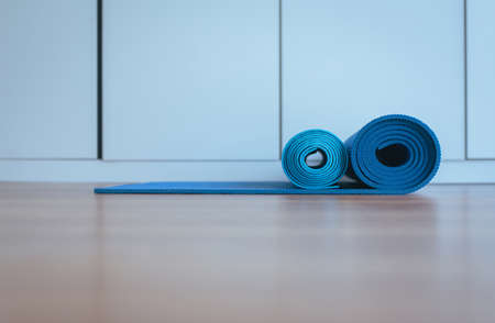 Blue yoga mat  half rolled after a workout equipment,Healthy fitness and sport concept