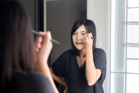 Asian woman correcting eyebrow shape with brush,Makeup and beautiful woman faceの写真素材