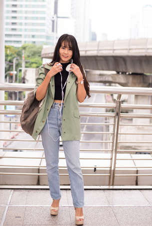 Beautiful young teen using headphones and listening to music at shopping center