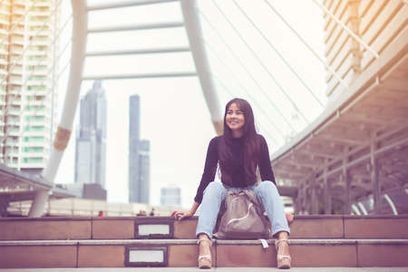 Portrait beautiful asian woman sitting in the city,Happy and smiling