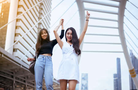 Portrait of couple happy young asian woman with arms raised,Hands up