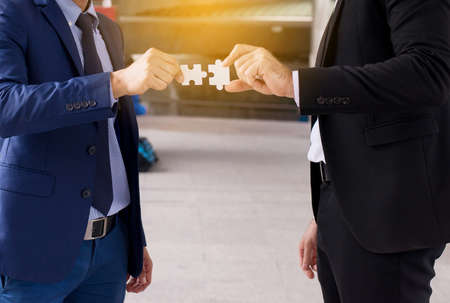 Business man hand making jigsaw and merging,Connecting together,Business thinking concept,Close upの写真素材