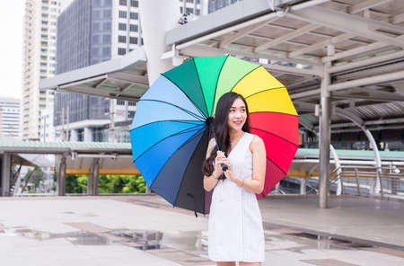 Asian young girl smling and holding umbrella in city,Lifestyle concept,Happy and smilingの写真素材