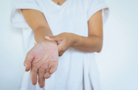 Woman hands checking her pulse with two fingers on wristの写真素材