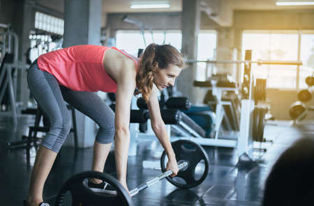 Sporty woman exercise with barbell,Female does the exercising at gymの写真素材