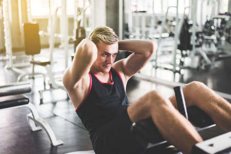 Storng man doing situp or crunches in gym,Men exercise muscular her stomachの写真素材