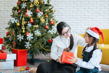 Sister make a christmas gift box to younger sister,Happy and smilingの写真素材