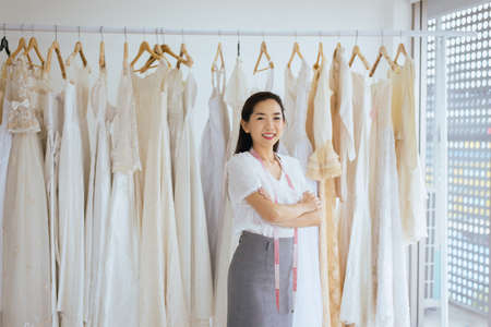 Portrait of asian woman wedding dress store owner,Beautiful dressmaker in shop and small businessの写真素材