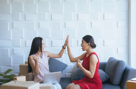 Small business woman owner raise up them hands and working at home office,Success upentrepreneur SME online businessの写真素材
