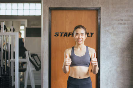 Fit asian woman thumb up and relax after the training session in gym,Concept healthy and lifestyle,Female taking a break after exercise and workout happy and smilingの写真素材