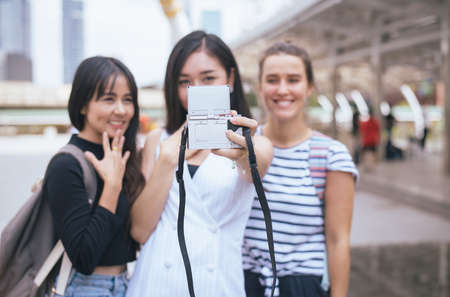 Blured of happy and smiling woman traveler is making her selfie in center city together,Beautiful girl walking on the streets,Best friendsの写真素材