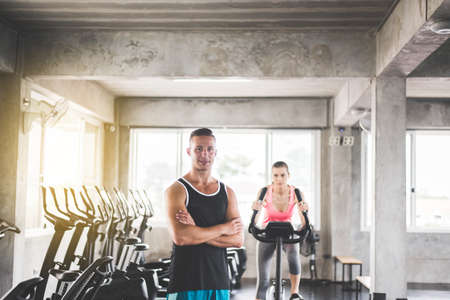Personal trainer man crossed arms and coaching woman exercise workout in gym,Concept healthy and  lifestyleの写真素材