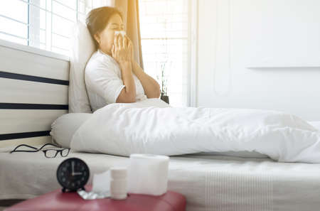 Elderly asian woman coughing and sitting on her bed,Concept of health