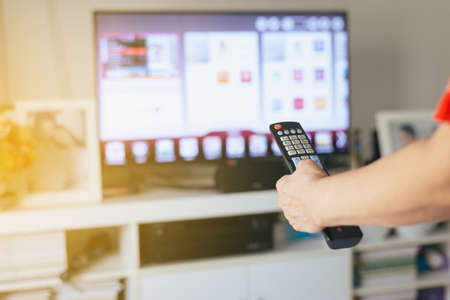 Hand woman with TV remote controlの写真素材