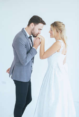 Portrait of groom with bride kissing in her hand on white background,Happy and smiling in engagement dayの写真素材