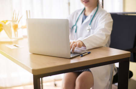 Close up of hand doctor woman typing on laptop computer keyboard in office room at hospital