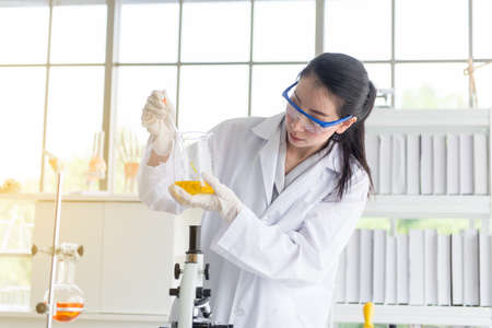 Scientist female working putting medical chemicals sample in test tube at laboratory